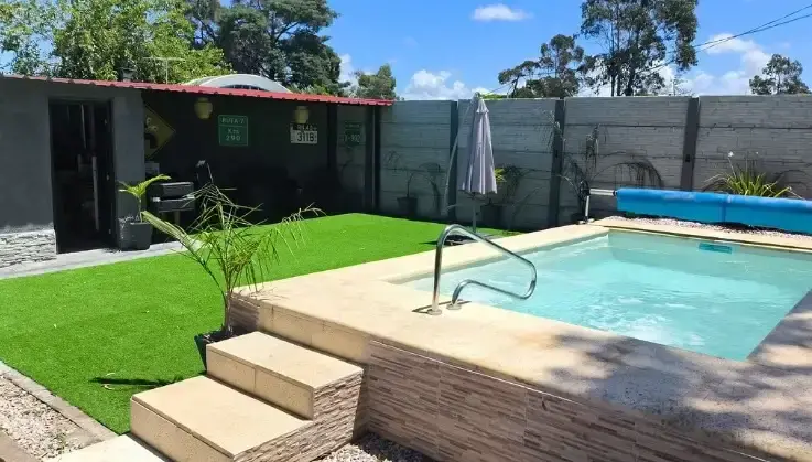Muro símil piedra · 2.5 m altura · Junto a piscina